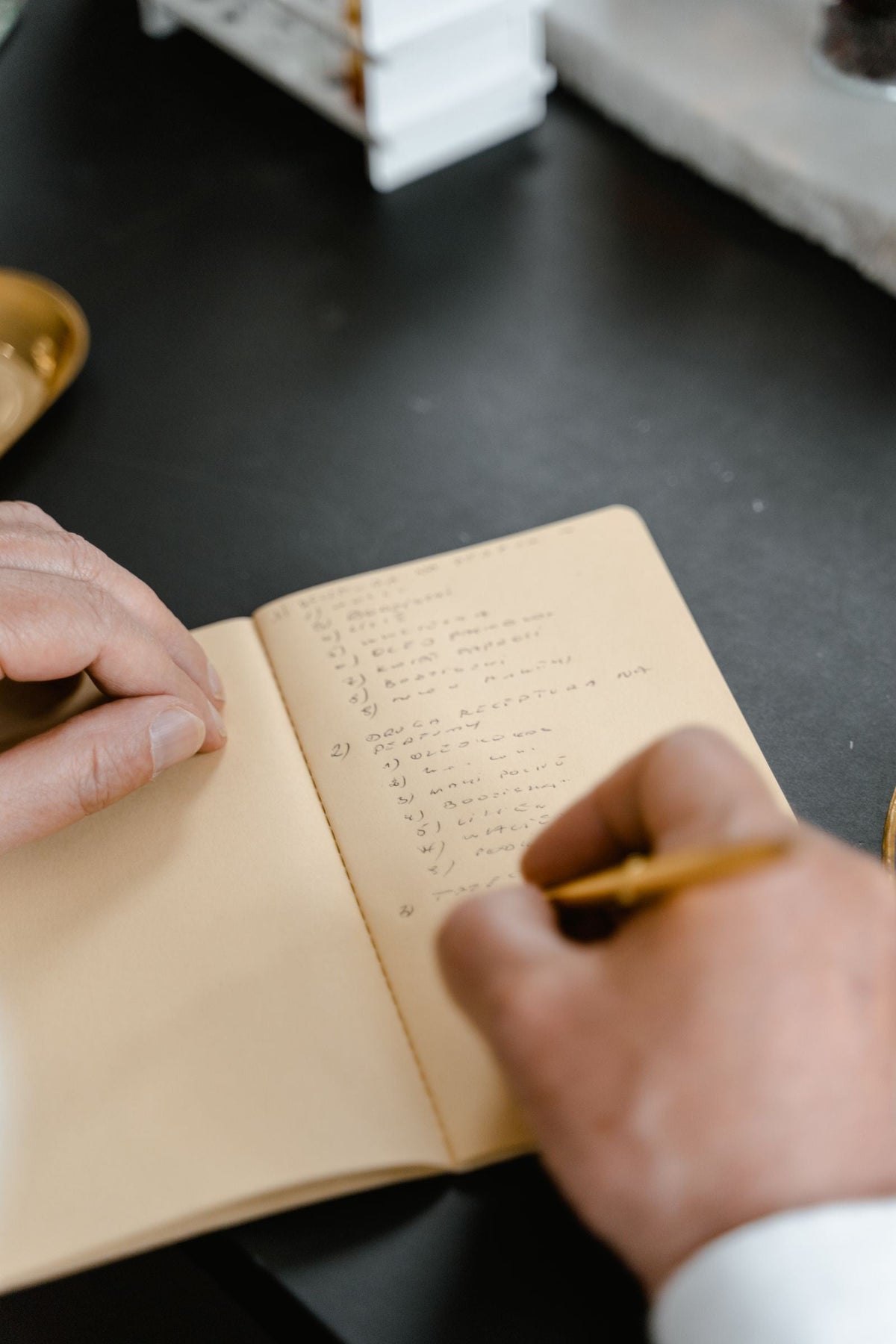 Hands writing a numbered checklist in a notebook for evaluating curcumin supplement choices