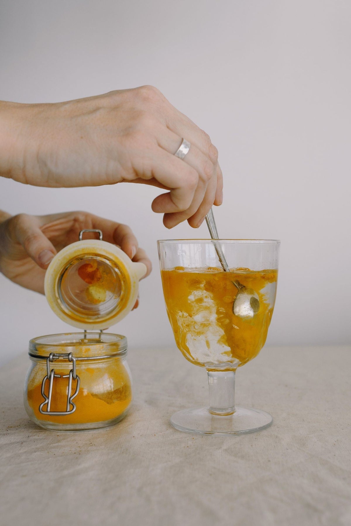 Turmeric-colored powder stirred into a glass of water, illustrating water solubility concepts for curcumin