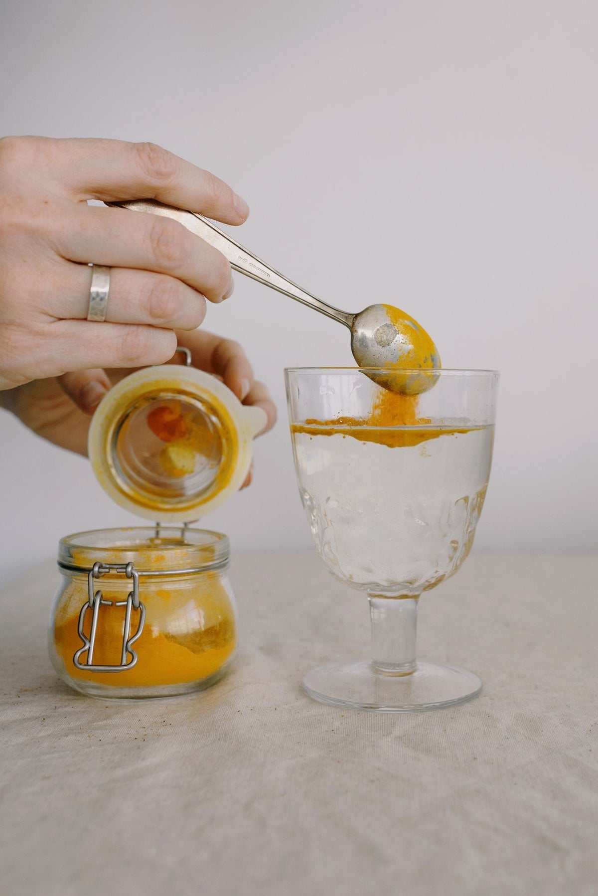 Curcumin-colored powder added to water, illustrating the BioSoluble® Curcumin™ solubility concept for everyday wellness education